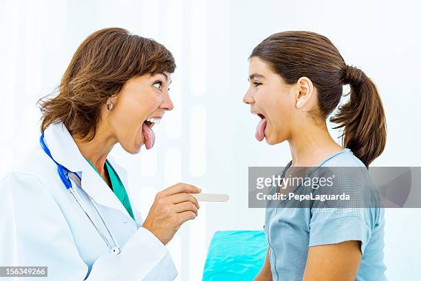 patient and doctor having fun together - girl tongue doctor stockfoto's en -beelden
