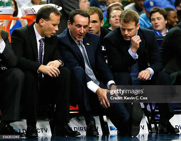 Head coach Mike Krzyzewski of the Duke Blue Devils holds his left knee after falling to the floor during a timeout against the Kentucky Wildcats...