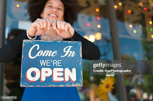 mujer con señal de abierto - african shop fotografías e imágenes de stock