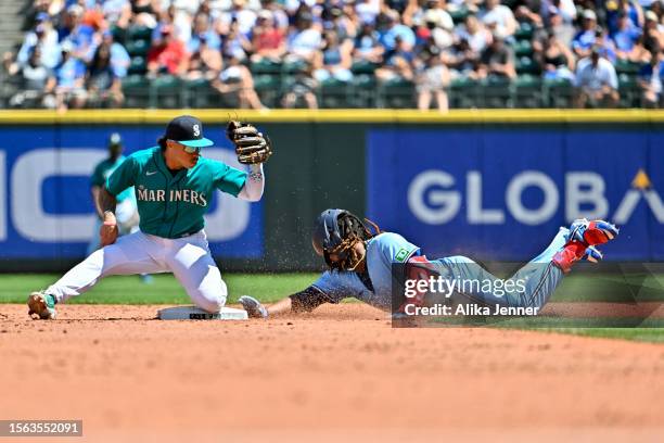 Vladimir Guerrero Jr. #27 of the Toronto Blue Jays slides into second base against Kolten Wong of the Seattle Mariners after hitting a double during...