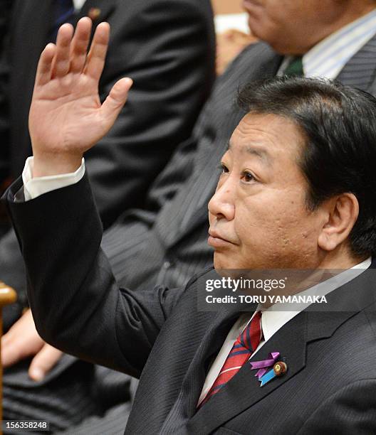 Japanese Prime Minister Yoshihiko Noda raises his hand before he answers questions during a one-by-one debate with President of the main opposition...