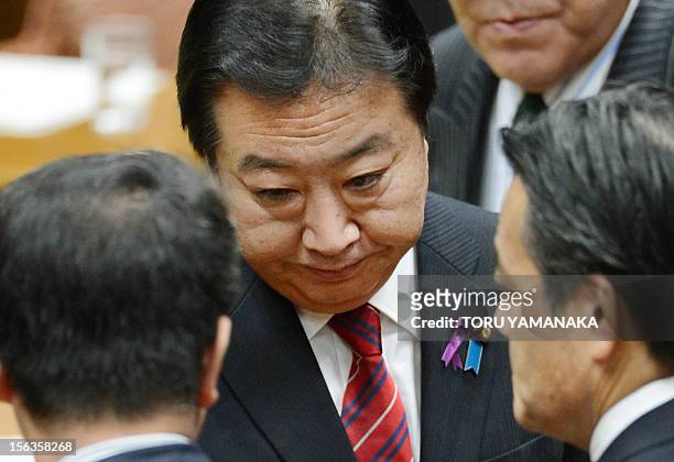 Japanese Prime Minister Yoshihiko Noda greets Deputy Prime Minister Katsuya Okada and National Strategy Minister Seiji Maehara after a one-by-one...