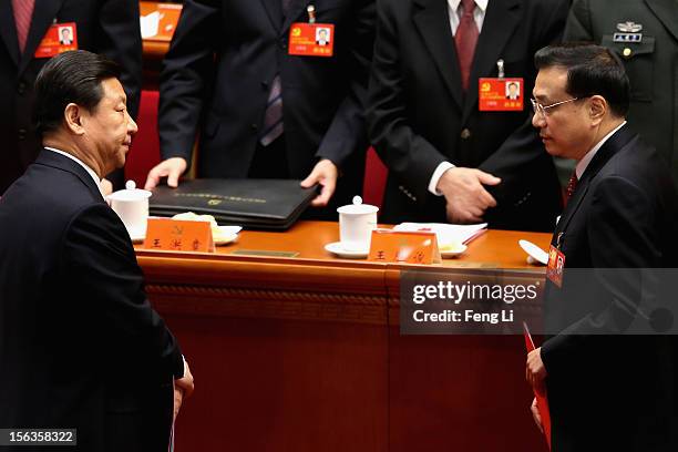 China's Vice President Xi Jinping and China's Vice-Premier Li Keqiang leave their seats after the closing session of the 18th National Congress of...