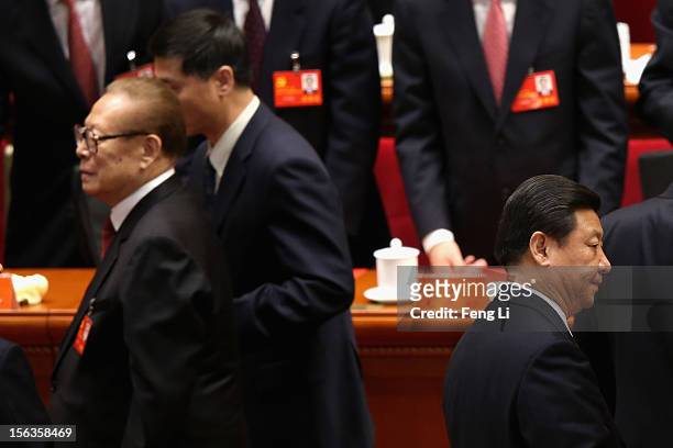 Former Chinese President Jiang Zemin walks past Chinese Vice President Xi Jinping after the closing session of the 18th National Congress of the...