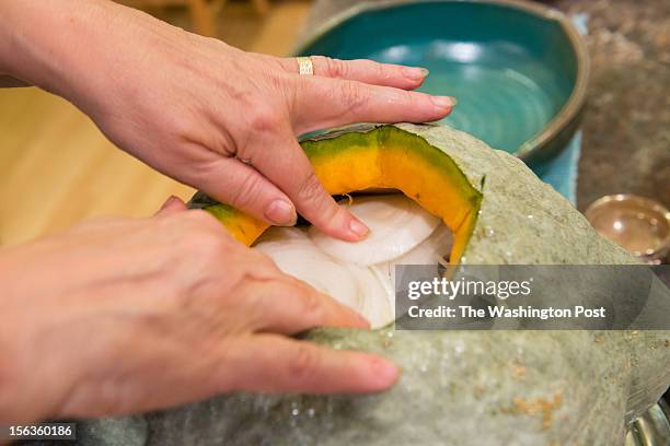 Resident Lisa Jorgenson puts together a s stuffed vegetarian Hubbard squash. Onions are used a top layer.