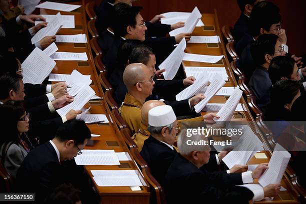 Special invited Buddhist monk delegate reads the Communist Party of China Central Committee report during the closing session of the 18th National...