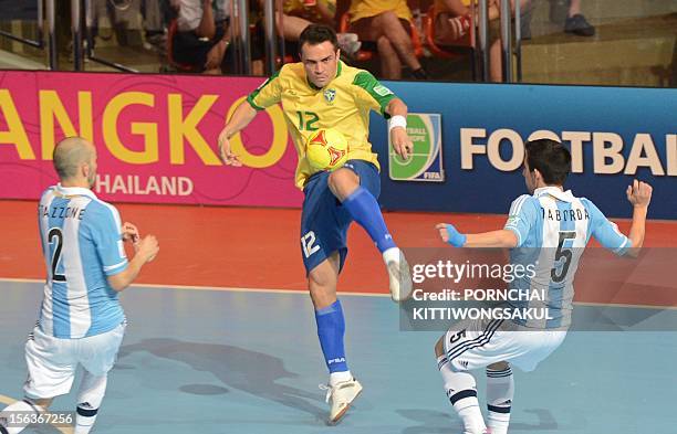 Falcao of Brazil battles for the ball with Damian Stazzone and Pablo Taborda of Argentina during the quarter-finals match of the FIFA Futsal World...
