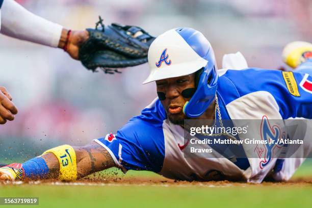 Ronald Acuña Jr. #13 of the Atlanta Braves slides into first base in the second inning during the game against the Milwaukee Brewers at Truist Park...