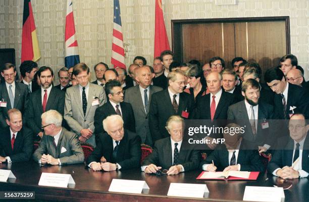 Soviet President Mikhail Gorbachev looks on while East German Prime Minister Lothar de Maiziere signs the treaty on German reunification 12 September...