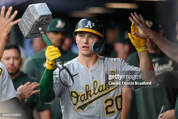 Zack Gelof of the Oakland Athletics celebrates in the dugout with a Thor's hammer prop after hitting a home run in the second inning against the...