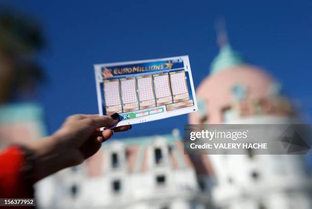 Person holds an Euromillions lottery ticket on november 14, 2012 in Nice. A lucky punter beat the French record for a Euromillions lottery today,...