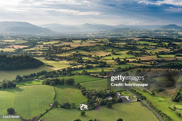 idyllic country meadows misty mountains aerial landscape - landscapes places stock pictures, royalty-free photos & images