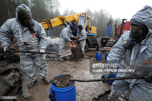 Belarus Emergencies Ministry employees reload pesticides into new plastic barrels in a forest near the village of Novaya Strazha, some 200 km...