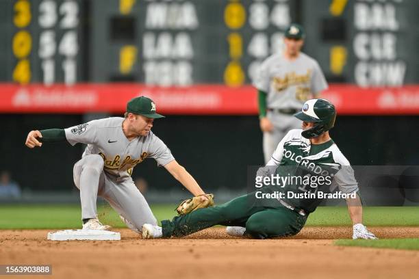 Randal Grichuk of the Colorado Rockies is tagged out at second base by Nick Allen of the Oakland Athletics after attempting to stretch a single into...