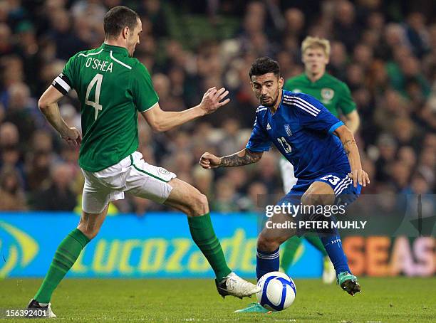 Greece's Stefanos Nikol Athanasiadis vies for the ball with Republic of Ireland's John O'Shea during their 2014 World Cup friendly football match at...