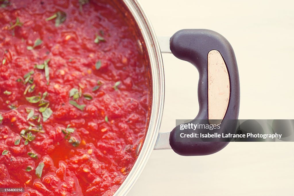 Tomato sauce with herbs in saucepan