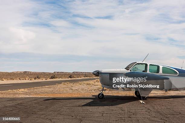 small plane parked on dirt track - propellermaschine stock-fotos und bilder
