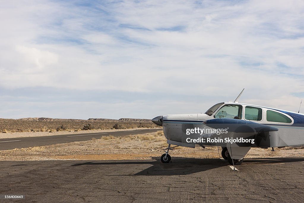 Small plane parked on dirt track
