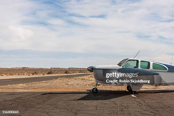 small plane parked on dirt track - propeller airplane stock pictures, royalty-free photos & images