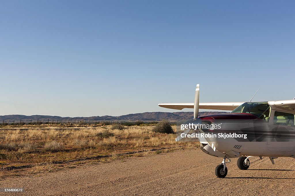 Front of small plane on dirt runway