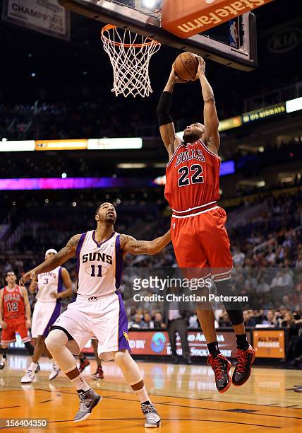 Taj Gibson of the Chicago Bulls slam dunks the ball over Markieff Morris of the Phoenix Suns during the NBA game at US Airways Center on November 14,...