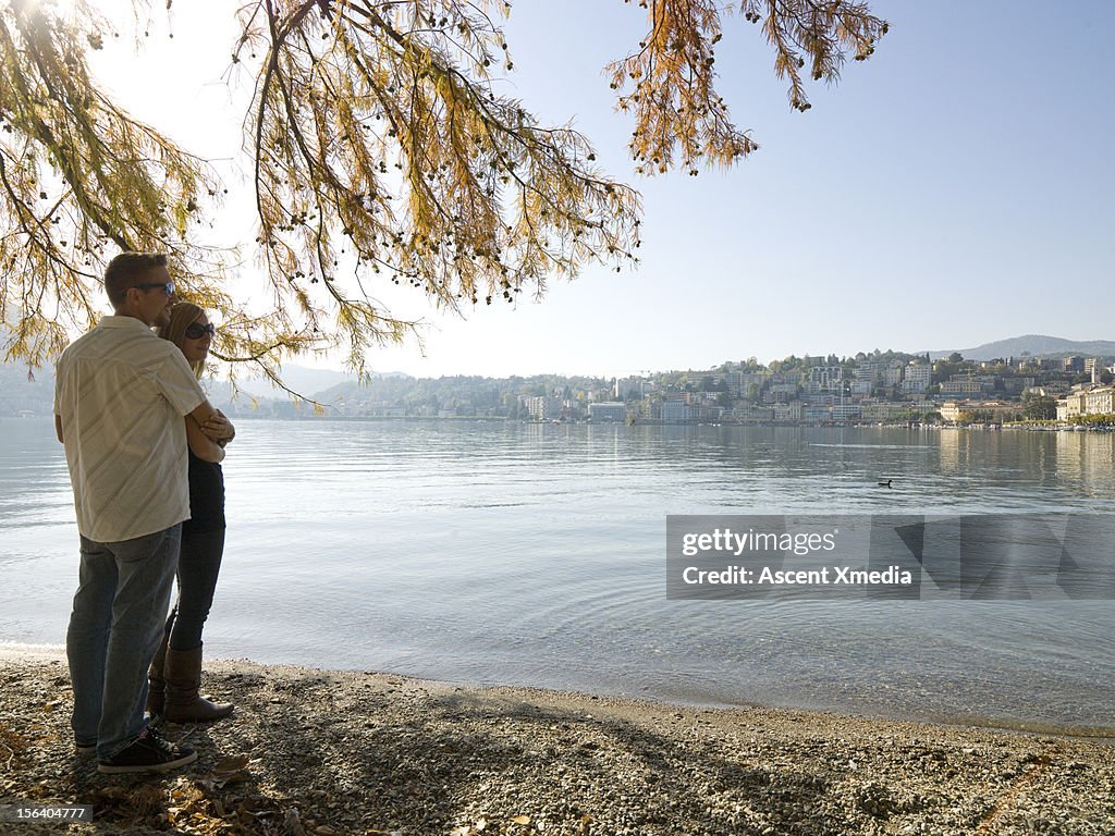 Couple emrace by water edge, Lake Lugano