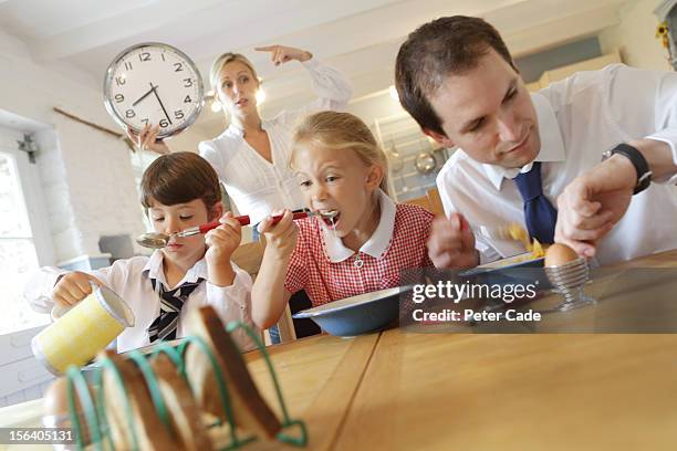 working family at breakfast, mum pointing at clock - family time stock pictures, royalty-free photos & images