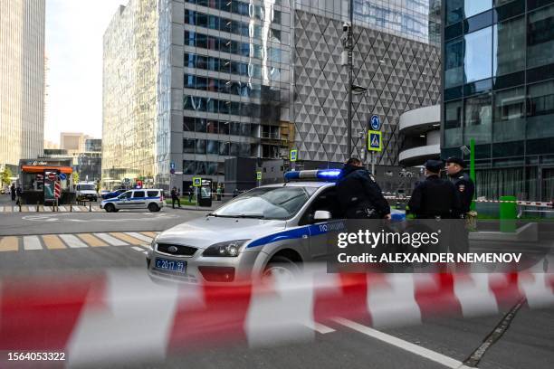 Police officers block off an area around a damaged office block of the Moscow International Business Center following a reported drone attack in...