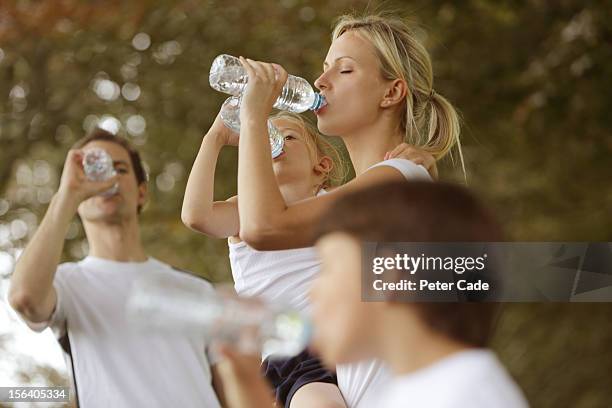 family drinking water after run - durst stock-fotos und bilder