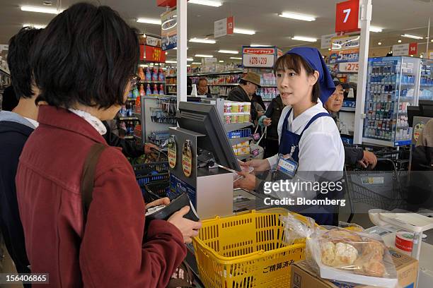 Customers pay at the check out counter in a Seiyu GK supermarket in Tokyo, Japan, on Wednesday, Nov. 14, 2012. Seiyu GK is a unit of Wal-Mart Stores...