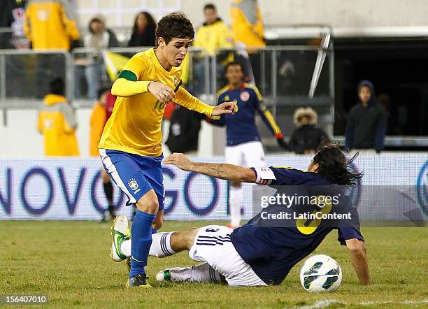 Mario Alberto Yepes of Colombia falls in front of Oscar from Brazil during a FIFA Friendly match between Colombia and Brazil at the MetLife Stadium...