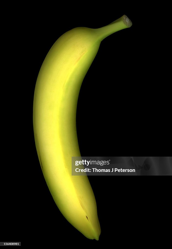 Single banana on black background