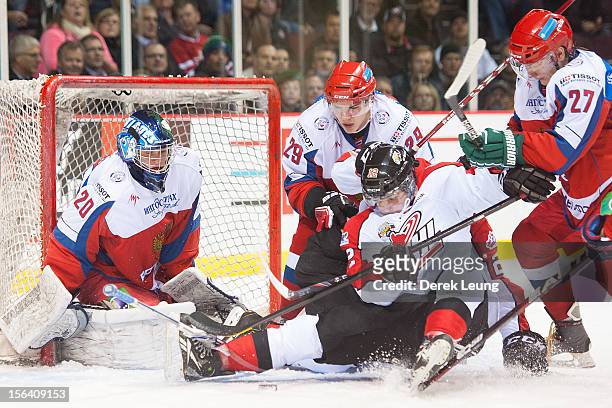 Sam Fioretti of the WHL All-Stars is knocked off his feet as he battles in front of the net of Andrei Makarov of team Russia during Game One of the...