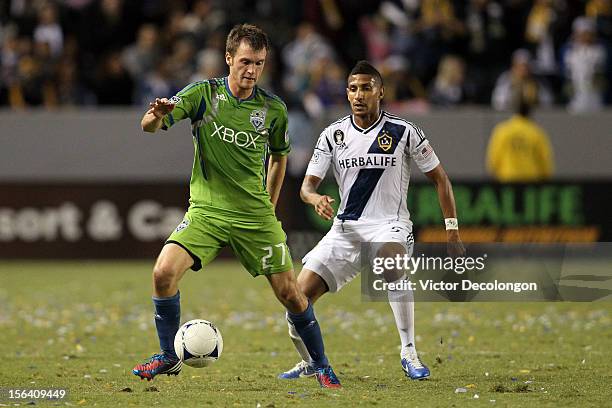 Alex Caskey of the Seattle Sounders controls the ball as Sean Franklin of the Los Angeles Galaxy looks on during Leg 1 of the Western Conference...