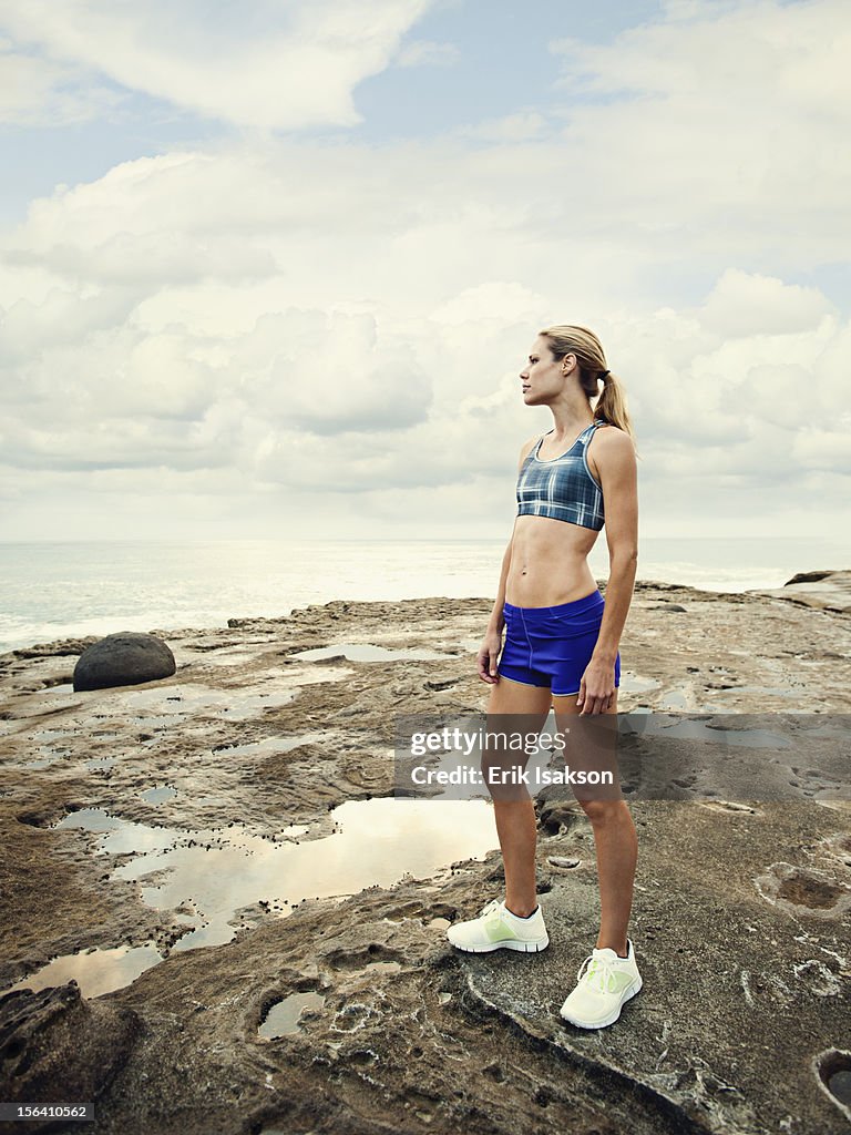 Caucasian woman standing on rocks near beach