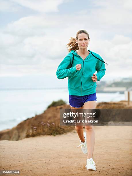caucasian woman running on beach - corredora de footing fotografías e imágenes de stock