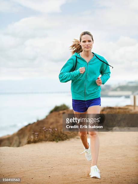 caucasian woman running on beach - 女性ランナー ストックフォトと画像