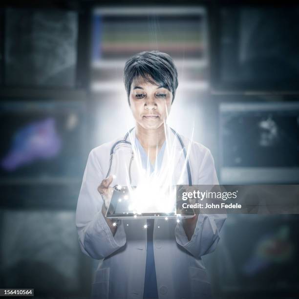 mixed race scientist holding glowing digital tablet - digital composite ストックフォトと画像