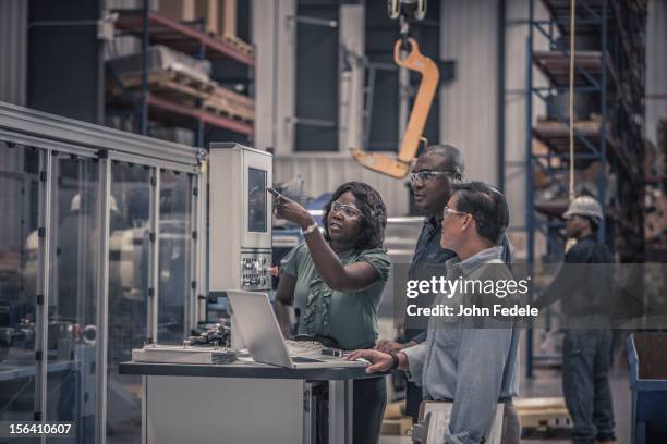 workers talking in factory - diversidad cultural fotografías e imágenes de stock