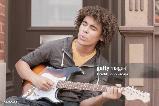 mixed race teenager playing electric guitar and whistling - person singing stock pictures, royalty-free photos & images