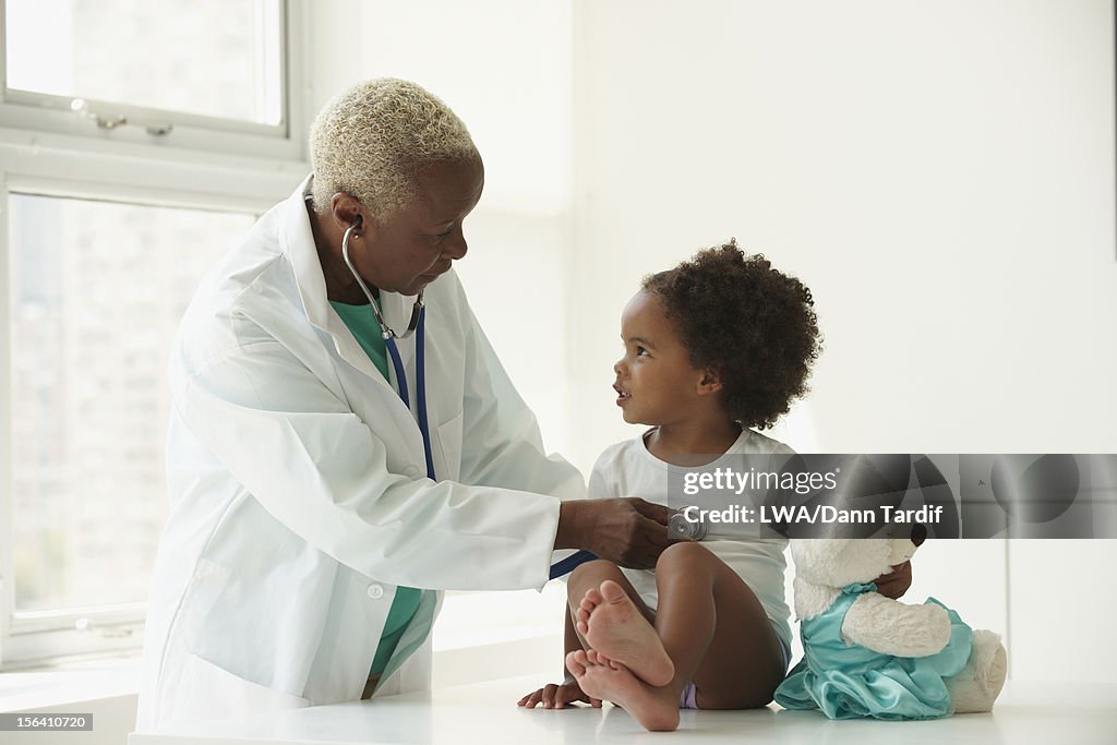 Black doctor examining girl