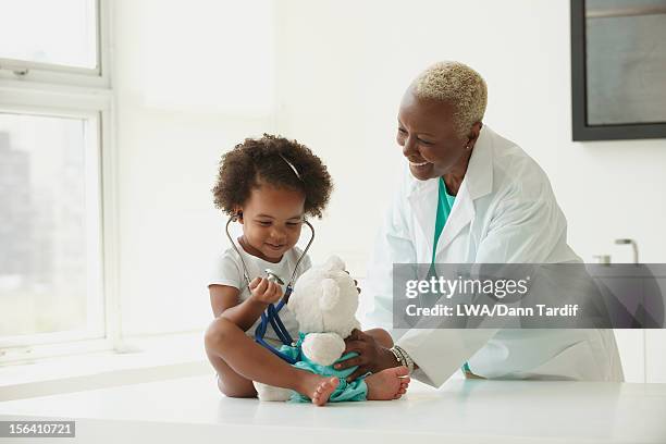 black doctor examining girl - pediatrician foto e immagini stock