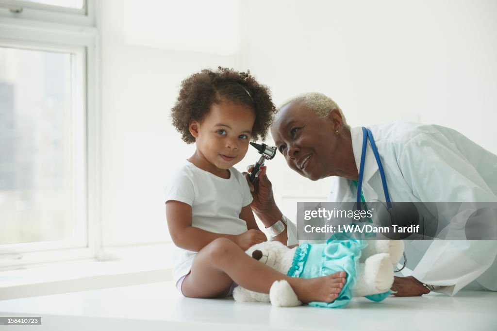 Black doctor examining girl