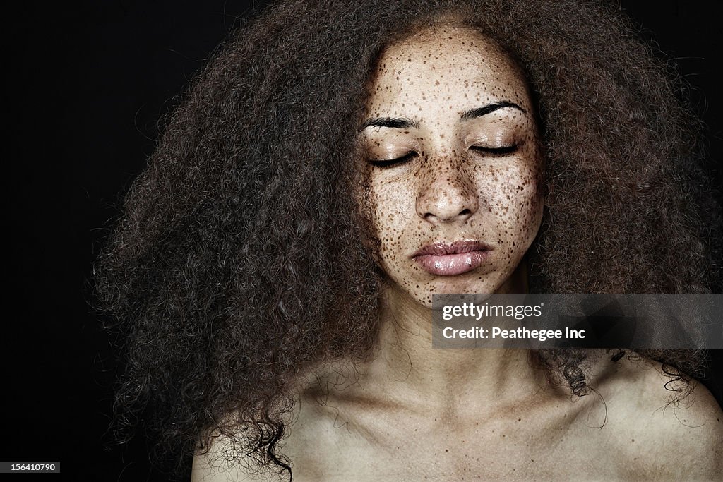 Serious, freckled mixed race woman