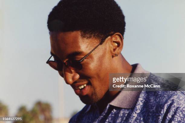 All-Star and championship winner Scottie Pippen of the Chicago Bulls smiles while signing an autograph wearing sunglasses and a collared shirt on the...