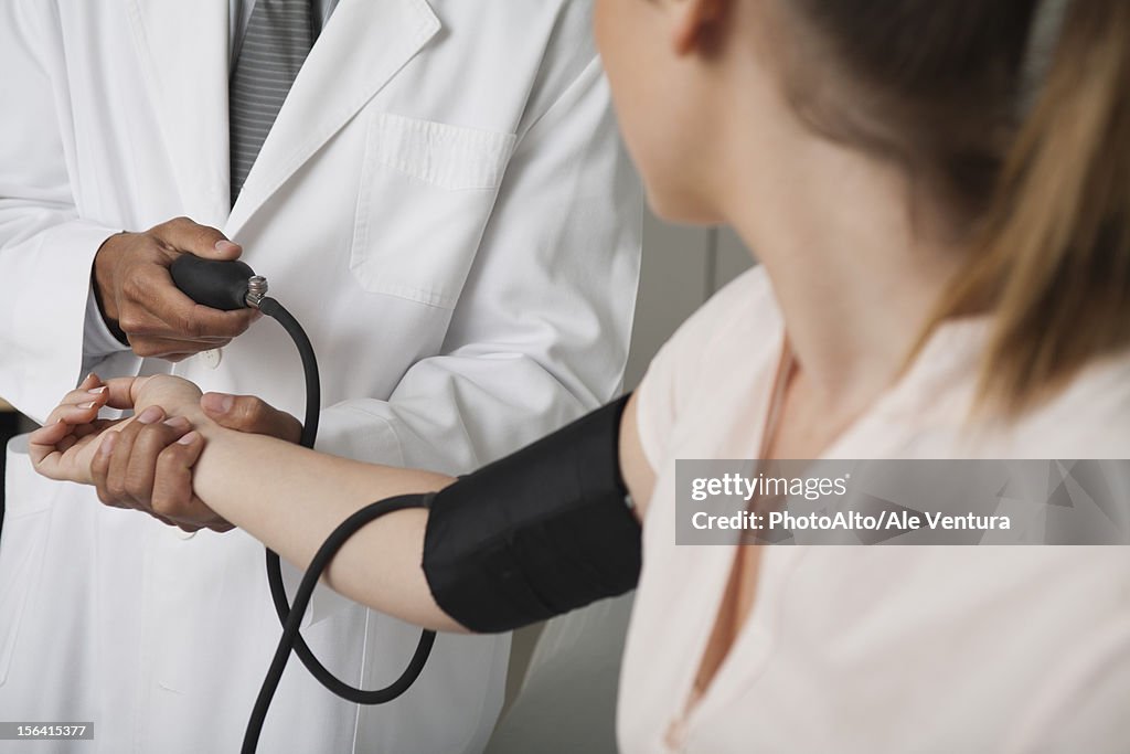 Doctor checking patient's blood pressure, cropped