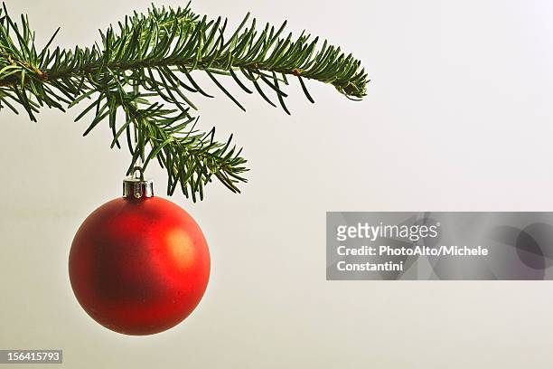 red christmas bauble hanging from christmas tree - boule noel photos et images de collection
