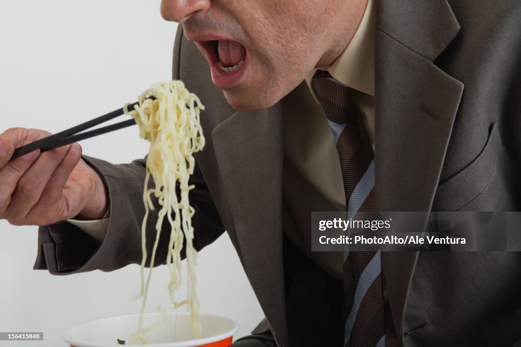 Businessman eating ramen noodles