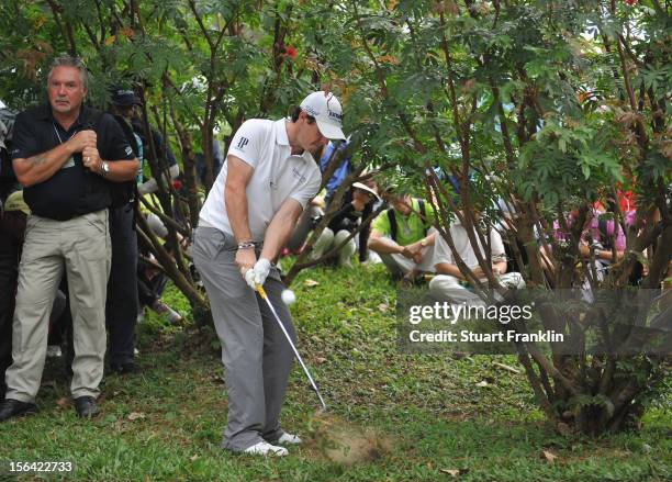 Rory McIlroy of Northern Ireland plays a shot left handed from a bush on the sixth hole during the first round of the UBS Hong Kong open at The Hong...