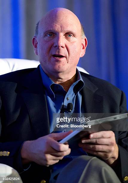 Steve Ballmer, chief executive officer of Microsoft Corp., is seen holding a Samsung laptop computer running Windows 8 software during an event at...